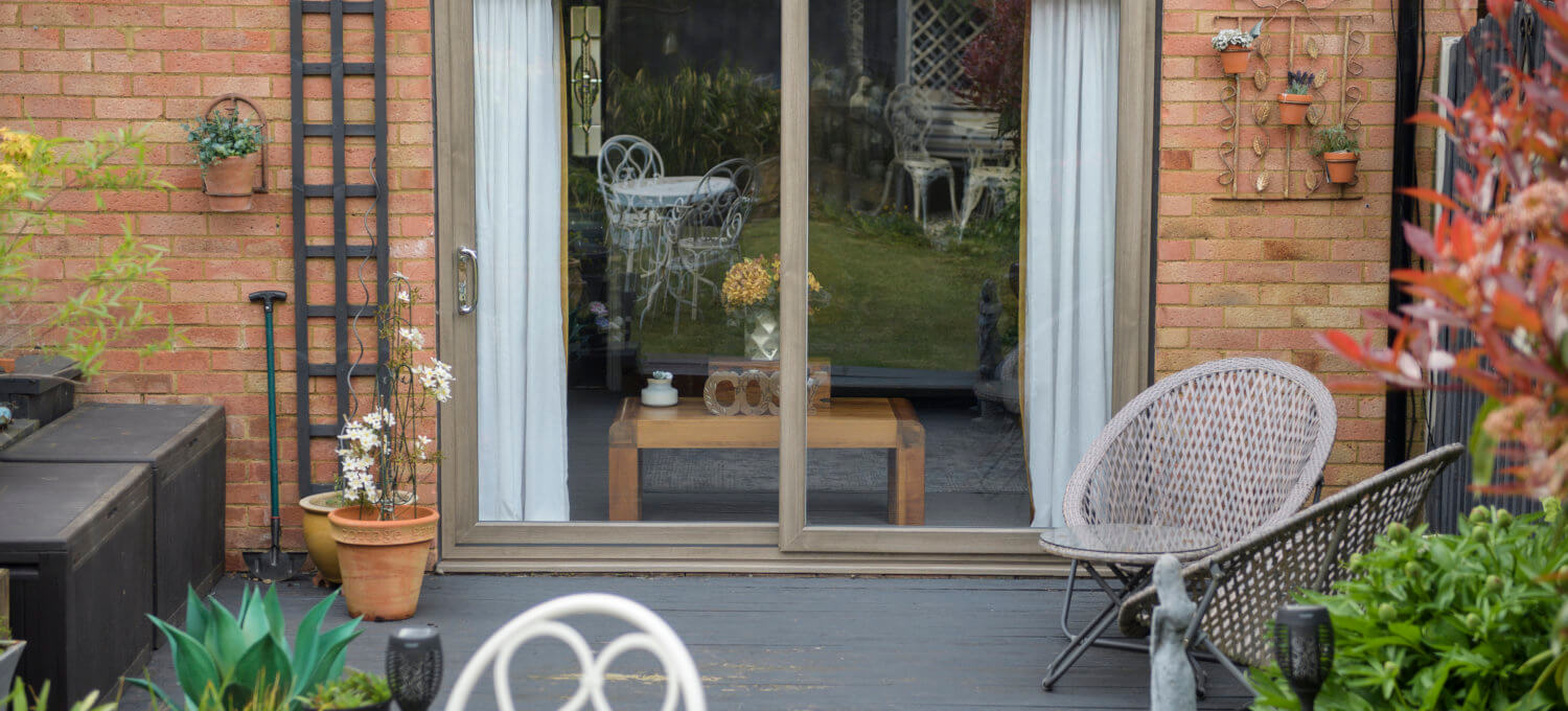 A Deceuninck Slider24 uPVC sliding patio door fitted to a brick house, opening onto a garden